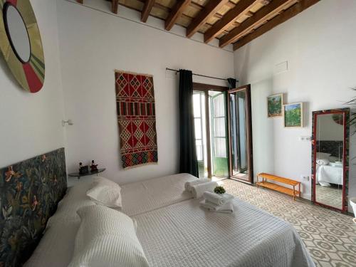 a bedroom with a large white bed in a room at Doña Lola Rooms in Conil de la Frontera