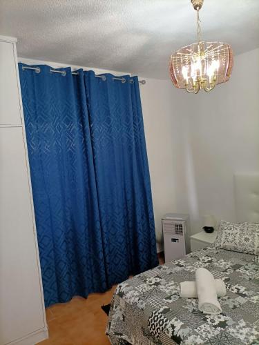 a bedroom with a blue curtain and a bed at Estudio Exterior Gran Via Madrid W in Madrid
