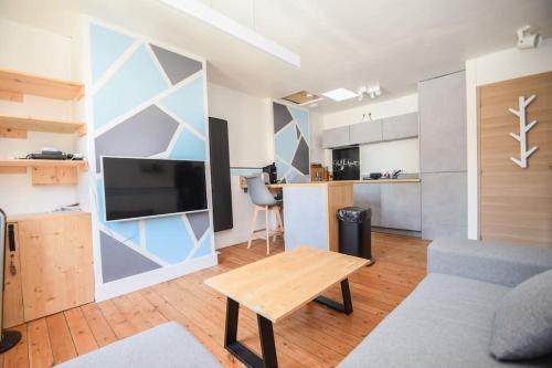 un salon avec un canapé et une table dans l'établissement COLLINS Studio Saint Malo intra muros 2 pers WIFI, à Saint-Malo