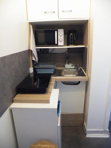 a small kitchen with a sink and a microwave at Charmant F2 de 30m2 moin cher à 25 min de Paris jusqu'à 5 personnes in Le Mée-sur-Seine