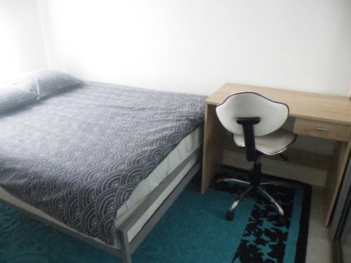 1 dormitorio con escritorio, 1 cama y 1 silla en Charmant F2 de 30m2 moin cher à 25 min de Paris jusqu'à 5 personnes, en Le Mée-sur-Seine