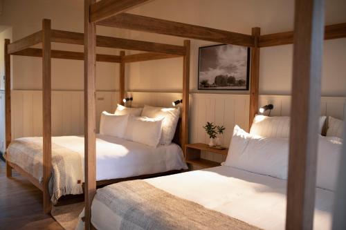 a bedroom with two beds with white pillows at Posada Campotinto in Carmelo