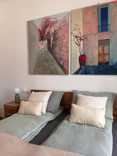 a bedroom with two beds and a painting on the wall at Apartamenty Rynek 18 in Żywiec