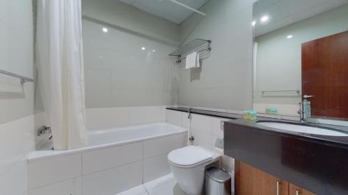 Un baño con inodoro, lavabo y bañera. en Marina Heights - Unique One Bedroom, en Dubái