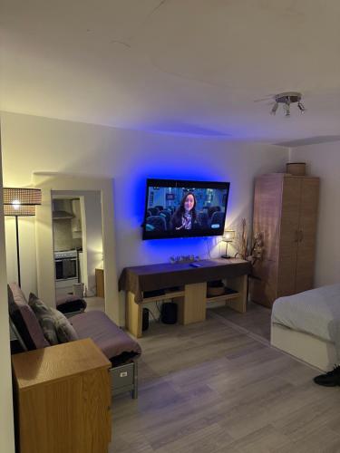 a living room with a tv on a wall at Stylish Studio flat - Watford Junction - Harry potter in Watford