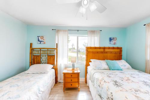 two beds in a bedroom with blue walls at Hip Harbour in North Fort Myers