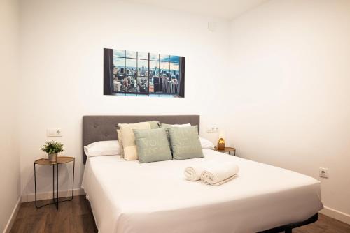una camera da letto con un letto bianco con due asciugamani di EMILIO LUQUE APARTAMENTO a Cordoba