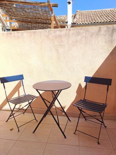 deux chaises et une table sur une terrasse dans l'établissement L'Etoile Arlesienne, à Arles