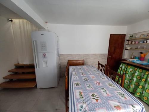 a kitchen with a refrigerator and a table with a blanket at hostel comunidad Ushuaia in Ushuaia