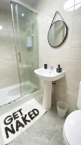 a bathroom with a shower and a sink and a mirror at Horizon Haven Studio in Manchester