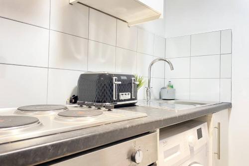 a kitchen with a toaster sitting on a stove at Horizon Haven Studio in Manchester