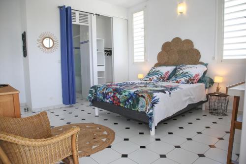 sypialnia z łóżkiem i krzesłem w obiekcie Villa Théo , chambre d'hôtes , petit déjeuner w mieście Sainte-Anne