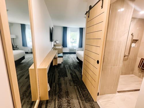a hotel room with a large mirror and a bedroom at La Place Rendez-Vous Hotel in Fort Frances