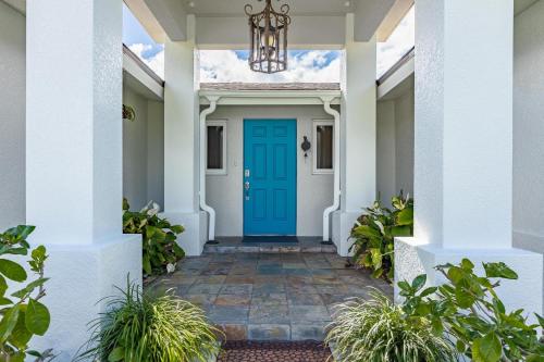 una porta blu su una casa bianca con piante di Gulf Access, Kayaks, PET Friendly - Escape to Versailles - Roelens Vacations a Cape Coral