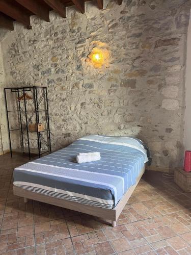 un lit dans une chambre avec un mur en pierre dans l'établissement L'Etoile Arlesienne, à Arles