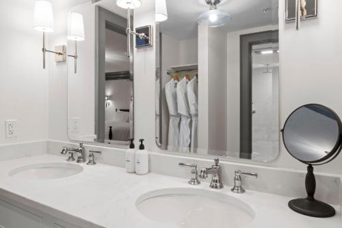 Baño blanco con 2 lavabos y espejo en The Davenport Inn, en Portsmouth