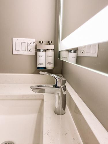 a bathroom with a sink and a mirror at La Place Rendez-Vous Hotel in Fort Frances