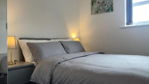 a bedroom with a white bed with a window at Luxury apartment in dudley in West Bromwich