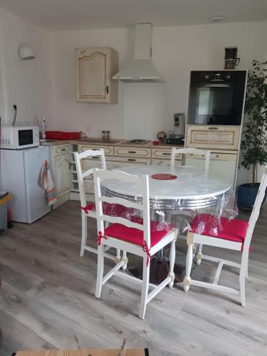 cocina con mesa blanca y sillas en Maison de bourg, comme a la maison ! en Cheviré-le-Rouge