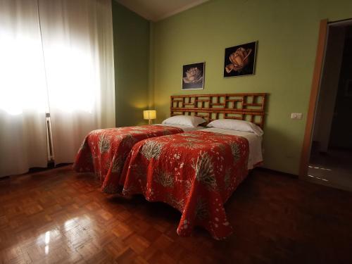a bedroom with a bed with a red blanket and a window at B&B Ospedale Maggiore Parma affittacamere in Parma