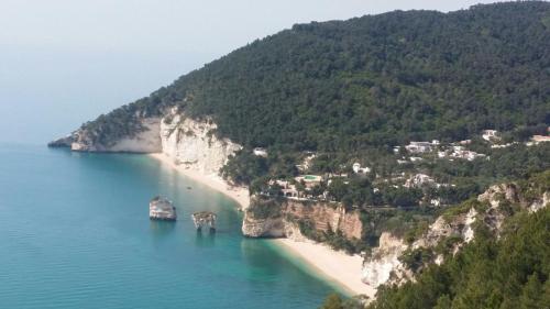 an island with a beach and a boat in the water at Olive&Sea Villa-OLIVE in Mattinata