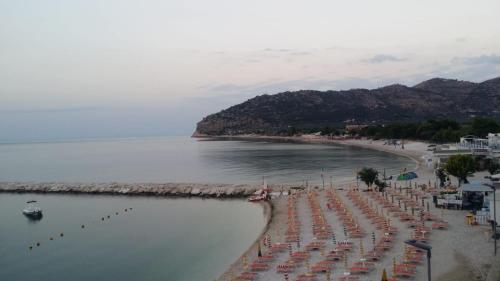 a beach with chairs and umbrellas in the water at Olive&Sea Villa-OLIVE in Mattinata