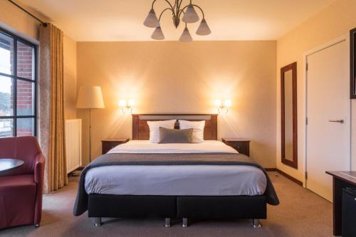een hotelkamer met een bed en een stoel bij Turnhout City Hotel in Turnhout