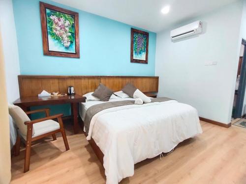 a bedroom with a bed and a desk and a bed sidx sidx sidx at Langkawi Country Lodge2 in Pantai Cenang