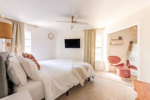 - une chambre blanche avec un lit et une télévision dans l'établissement Downtown Pearl Bungalow at Beer Ranch Project, à Wimberley