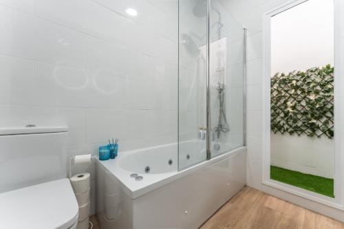 a white bathroom with a shower and a toilet at Casa Augusto - junto al Teatro Romano, con garaje in Merida