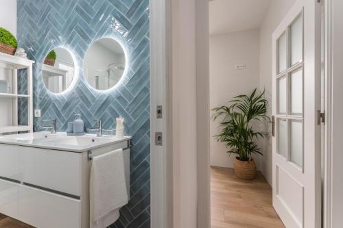 a bathroom with a sink and a mirror at Casa Augusto - junto al Teatro Romano, con garaje in Merida