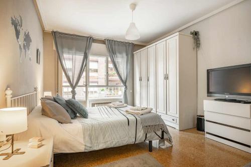 a bedroom with a bed and a large window at Apto Lourmar El Berrón in Berrón