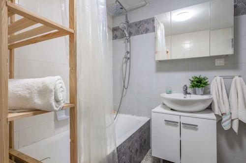 a bathroom with a sink and a shower and a tub at Apto Lourmar El Berrón in Berrón