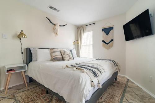 a bedroom with a bed and a tv on a wall at Downtown Lonestar Bungalow at Beer Ranch Project in Wimberley