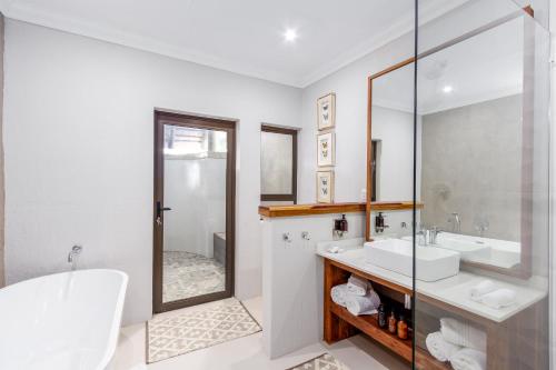 a white bathroom with a sink and a mirror at Simbavati Amani in Klaserie Private Nature Reserve