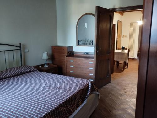 a bedroom with a bed and a dresser and a mirror at Capretto Gian Piero in San Quirico