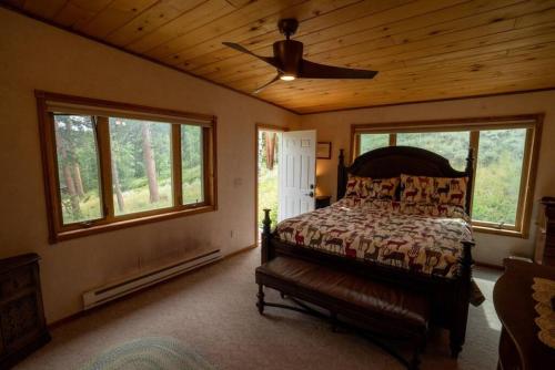 sypialnia z łóżkiem i wentylatorem sufitowym w obiekcie Warm Woodland Getaway with Land w mieście Red Feather Lakes