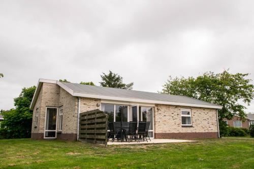 a brick house with a table and chairs in it at Vakantiepark Klein Vaarwater in Buren