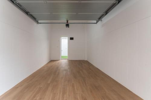 an empty room with white walls and a wooden floor at Casa Augusto - junto al Teatro Romano, con garaje in Merida