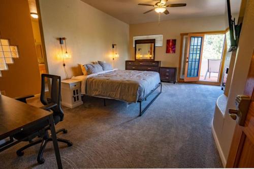 a bedroom with a bed and a desk and a chair at Serenity Skyline Lodge in Colorado Springs