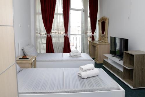 a hotel room with two beds and a television at Hotel Xhema in Pristina