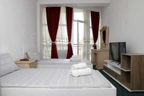 a hotel room with two beds and a television at Hotel Xhema in Pristina