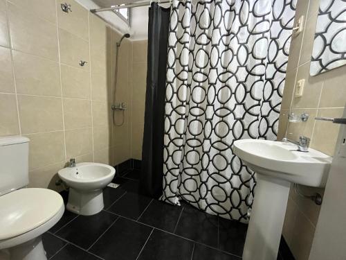 a bathroom with a toilet and a sink and a shower at Hotel Rosario in Rosario