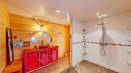 La salle de bains est pourvue d'une armoire rouge et d'une douche. dans l'établissement Calme et chaleureux gîte de campagne., à Voiteur