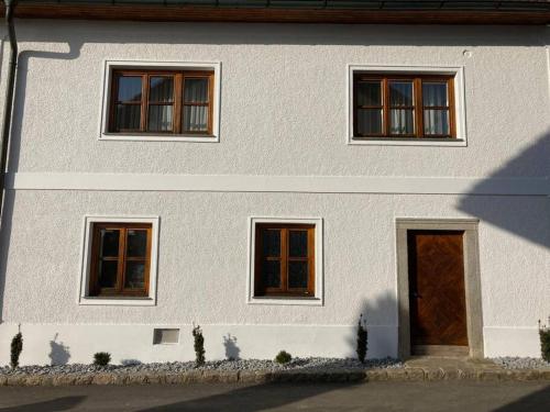 a white house with three windows and a door at Wohnen im Grünen in Pregarten