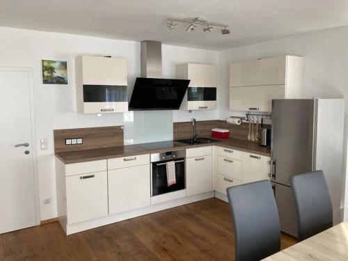 a kitchen with white cabinets and a stainless steel refrigerator at Wohnen im Grünen in Pregarten