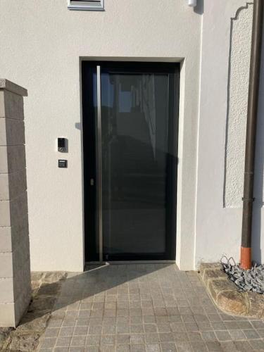 a black door on a white building at Wohnen im Grünen in Pregarten