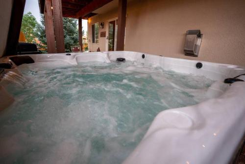 a bath tub filled with water in a bathroom at Bear Creek Lodge - Spa - Fire Table - 3min to Trails in Colorado Springs