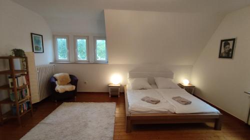 ein Schlafzimmer mit einem Bett, einem Stuhl und zwei Lampen in der Unterkunft FeWo im Naturschutzgebiet in Hiddenhausen
