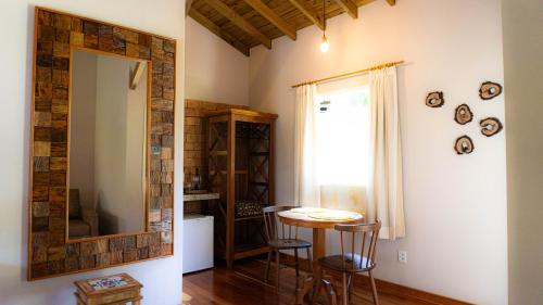 新文達移民鎮的住宿－Pousada Altoé da Montanha，一间带镜子和桌子的用餐室